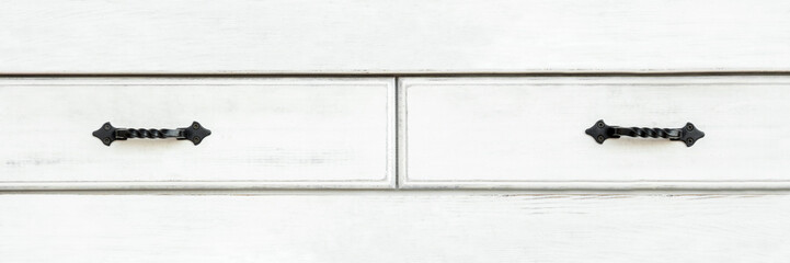 White wooden drawers front with forged metal handles, panoramic, banner. Aged painted furniture...
