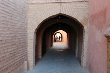 Fototapeta na wymiar Ancient alley with stone arch in medina of Marrakesh (Morocco)