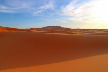 Fototapeta na wymiar Shadows in the sand dunes of Erg Chebbi desert during golden hour at sunset in Morcco