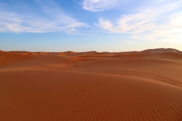 Fototapeta na wymiar Shadows in the sand dunes of Erg Chebbi desert during golden hour at sunset in Morcco