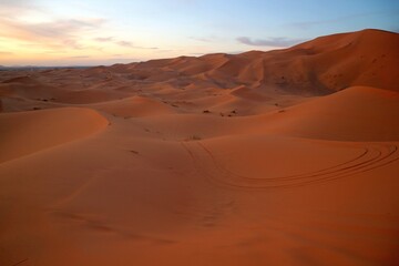 Fototapeta na wymiar Many dunes in the sand dunes of Erg Chebbi desert during golden hour at sunset in Morcco