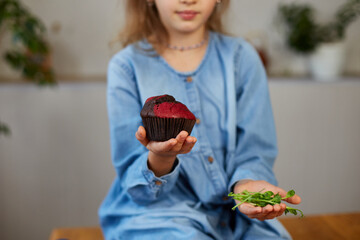 Little girl comparing food, choosing sweet cake against microgreen UnHealthy habit