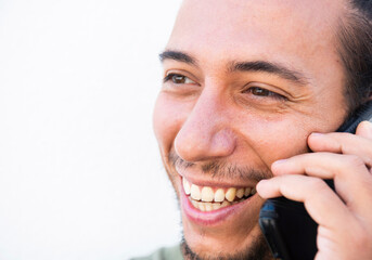 Smiling man talking on mobile phone over white background