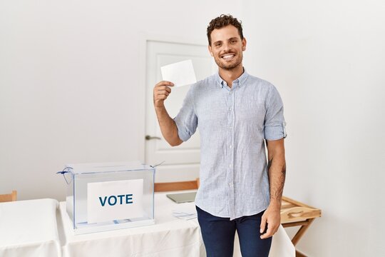 Young hispanic man smiling confident holding vote at electoral college