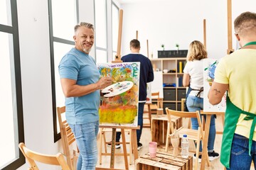 Group of middle age paint students drawing at art studio.