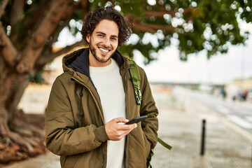 Handsome hispanic man using smartphone at the city