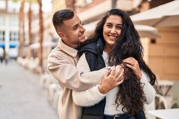 Fototapeta premium Man and woman couple hugging each other standing at street
