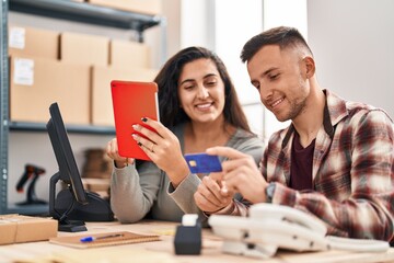 Man and woman ecommerce bussines workers using touchpad and credit card at office