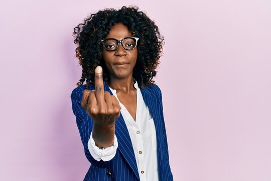 Young african american woman wearing business clothes and glasses showing middle finger, impolite and rude fuck off expression