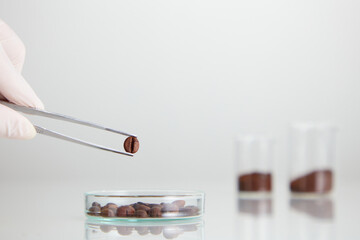 Closeup view of coffee extract decorated with petri dish with laboratory equipment in white background 
