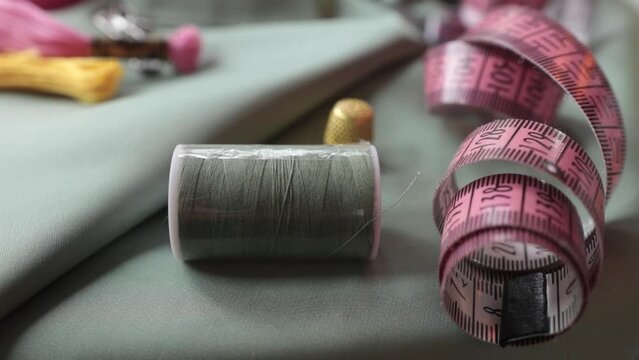 Close up shot of thimble and thread.  Tailor craft equipment  