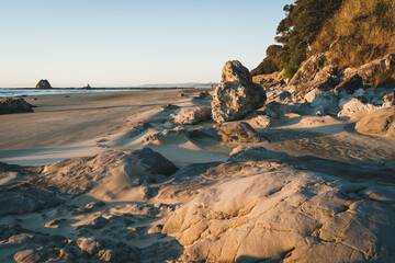 Rock formations against blue sky on a sunny day at Mangawhai Heads Beach, New Zealand