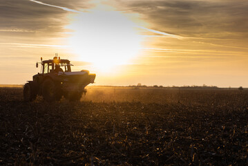 Fototapeta premium Tractor spreading artificial fertilizers in field