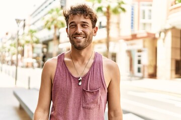 Young hispanic man smiling confident walking at street