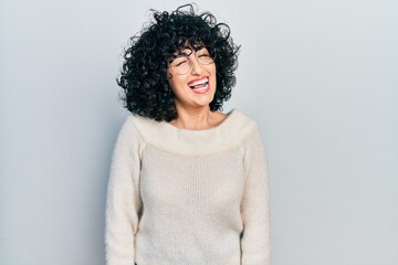 Young middle east woman wearing casual white tshirt winking looking at the camera with sexy...