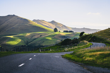 Long rural road leading to the mountains in Akaroa, New Zealand
