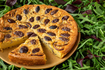 Farinata (Italian chickpea pancake) with kalamata olives and red onion with spinach, rucola and beet leaves salad.