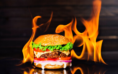 delicious hamburger burger with flame on a dark background