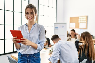 Young businesswoman smiling happy using touchpad while partners working at the office.
