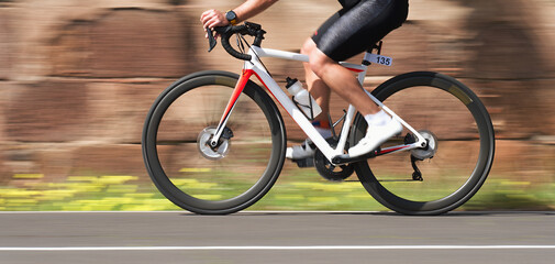 Road bike cyclist man cycling, athlete on a race cycle. Panning technique used
