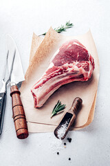 Cowboy steak on bone with spices. Beefsteak cooking top view