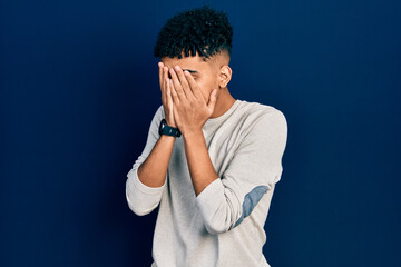 Fototapeta na wymiar Young african american man wearing casual clothes with sad expression covering face with hands while crying. depression concept.
