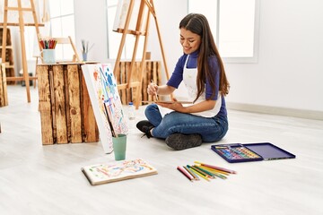 Young latin woman smiling confident drawing at art studio