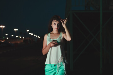 Girl on background of dark city. Danger of night walks for beautiful women.