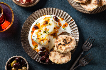 Cilbir or Turkish Eggs. mezze: poached eggs topped over herbed greek yogurt, then drizzled with hot spiced paprika olive oil. Traditional Turkish breakfast with rahat