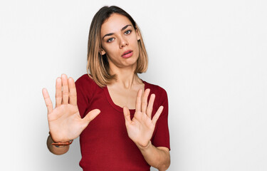 Young blonde girl wearing casual clothes moving away hands palms showing refusal and denial with afraid and disgusting expression. stop and forbidden.