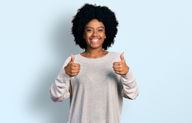 Young african american woman wearing casual clothes success sign doing positive gesture with hand, thumbs up smiling and happy. cheerful expression and winner gesture.