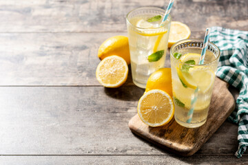 Glass of fresh lemonade on wooden table. Copy space