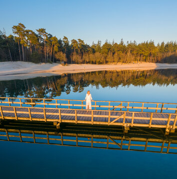 Aerial view of a woman on the bridge at Henschotermeer lake in Woudenberg, Netherlands.