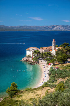 Aerial view of people on a beautiful beach along the coast with a small town, Split, Croatia.