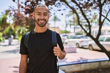 Fototapeta premium Young african american man smiling confident wearing backpack at park