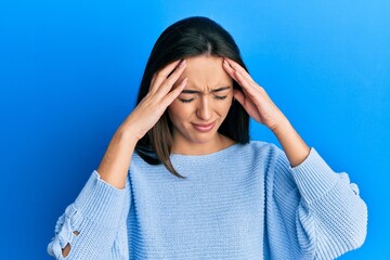 Young hispanic girl wearing casual clothes with hand on head for pain in head because stress. suffering migraine.