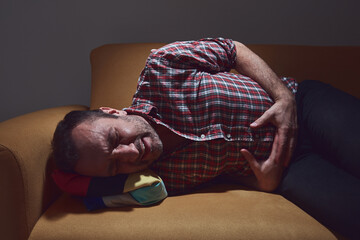 Man with pain in the stomach at home.