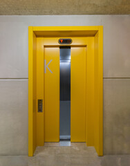 Shot of a yellow door of elevator with letter K on it © Raphael Paschalidis/Wirestock Creators