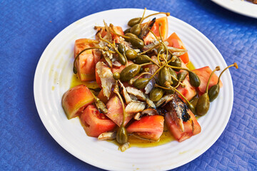  Plate of healthy tomato and fish salad on paper surface