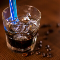glass of coffee ice drink on wooden table close up square