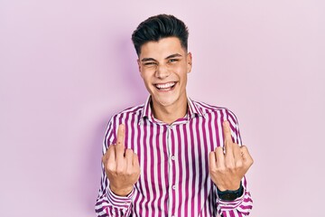 Obraz premium Young hispanic man wearing casual clothes showing middle finger doing fuck you bad expression, provocation and rude attitude. screaming excited