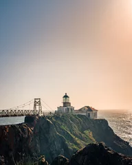 Poster Vertical shot of the Point Bonita Lighthouse at sunset in San Francisco. © Peter Ning/Wirestock Creators