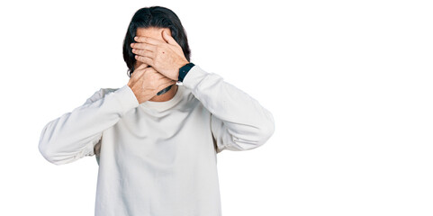 Middle age caucasian man wearing casual clothes covering eyes and mouth with hands, surprised and shocked. hiding emotion