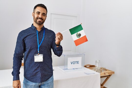 Young hispanic man smiling confident holding mexico flag standing at electoral college