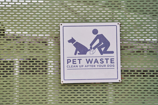 A sign in the park warning you to clean up after your pets. High quality photo