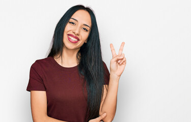 Young hispanic girl wearing casual t shirt smiling with happy face winking at the camera doing...