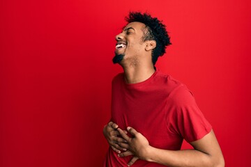 Young african american man with beard wearing casual red t shirt with hand on stomach because nausea, painful disease feeling unwell. ache concept.