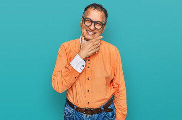 Middle age indian man wearing casual clothes and glasses looking confident at the camera smiling with crossed arms and hand raised on chin. thinking positive.