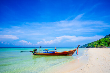 Obraz premium KRABI, THAILAND - Thai wooden motorboat, boat trips at sea, Clean white sand beaches, and emerald green sea.soft focus.