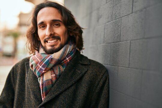 Young hispanic man smiling happy standing at the city.